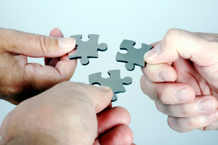 Three Persons with Puzzle in Hand Coming Together Royalty Free Stock Photo